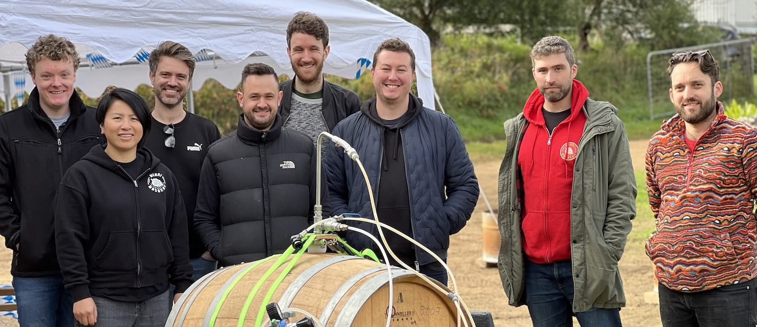The Merri Mashers posing for a photo in front or a beer barrel